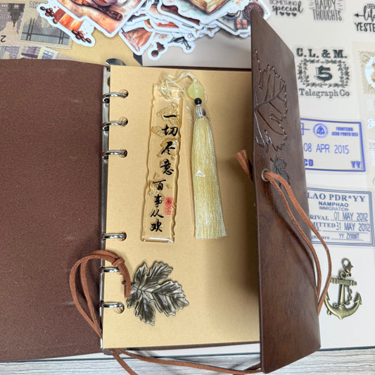 Brown leather-bound notebook with decorative elements on a textured surface