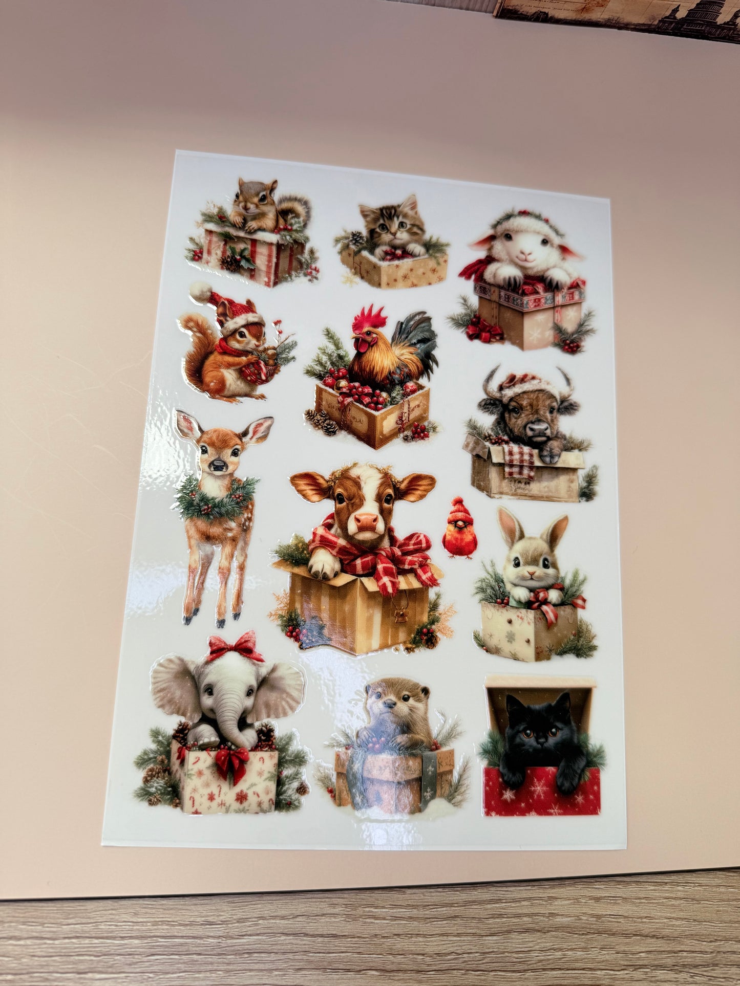 Sheet of decorative stickers with various animal designs on a beige surface.