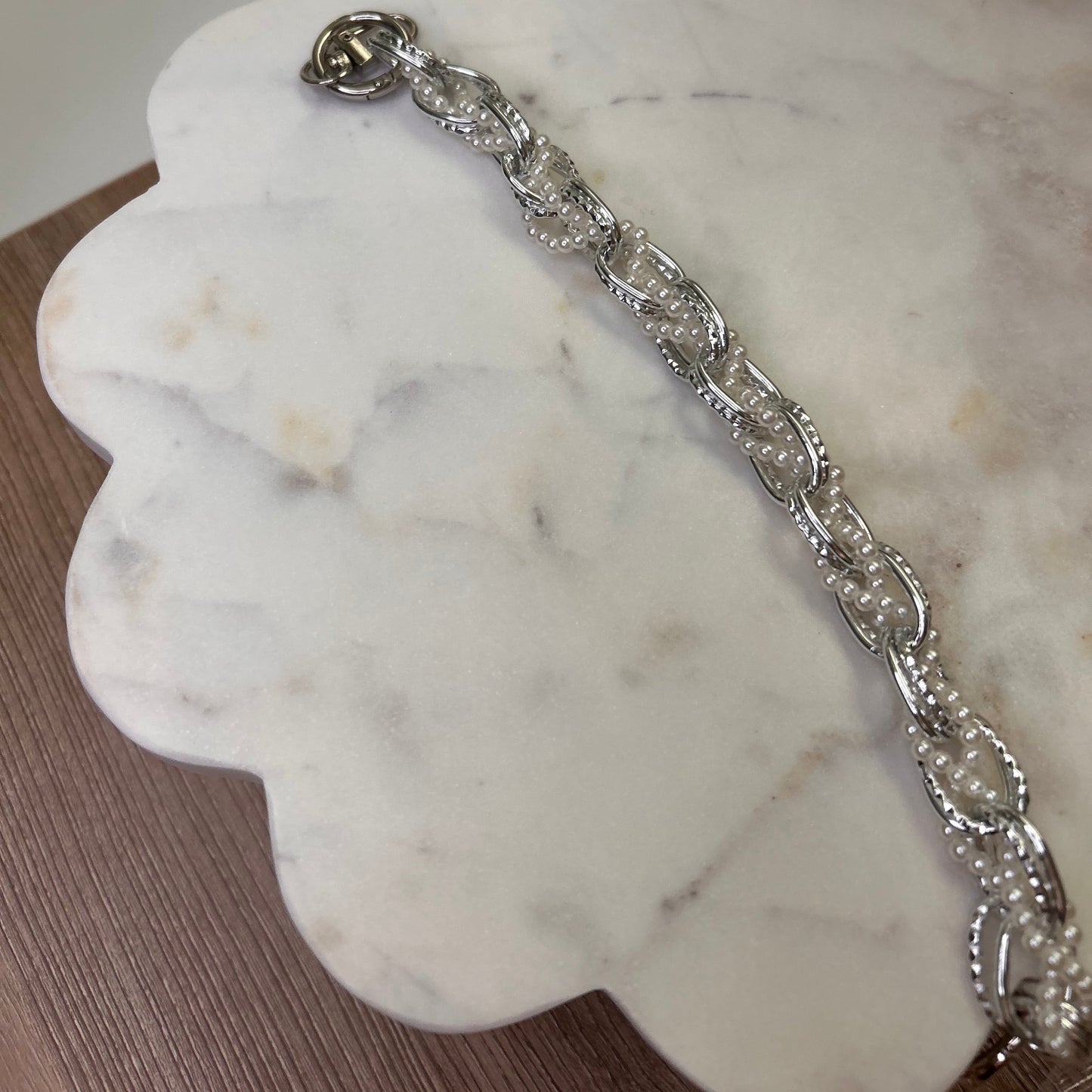 Silver bracelet on a white marble surface