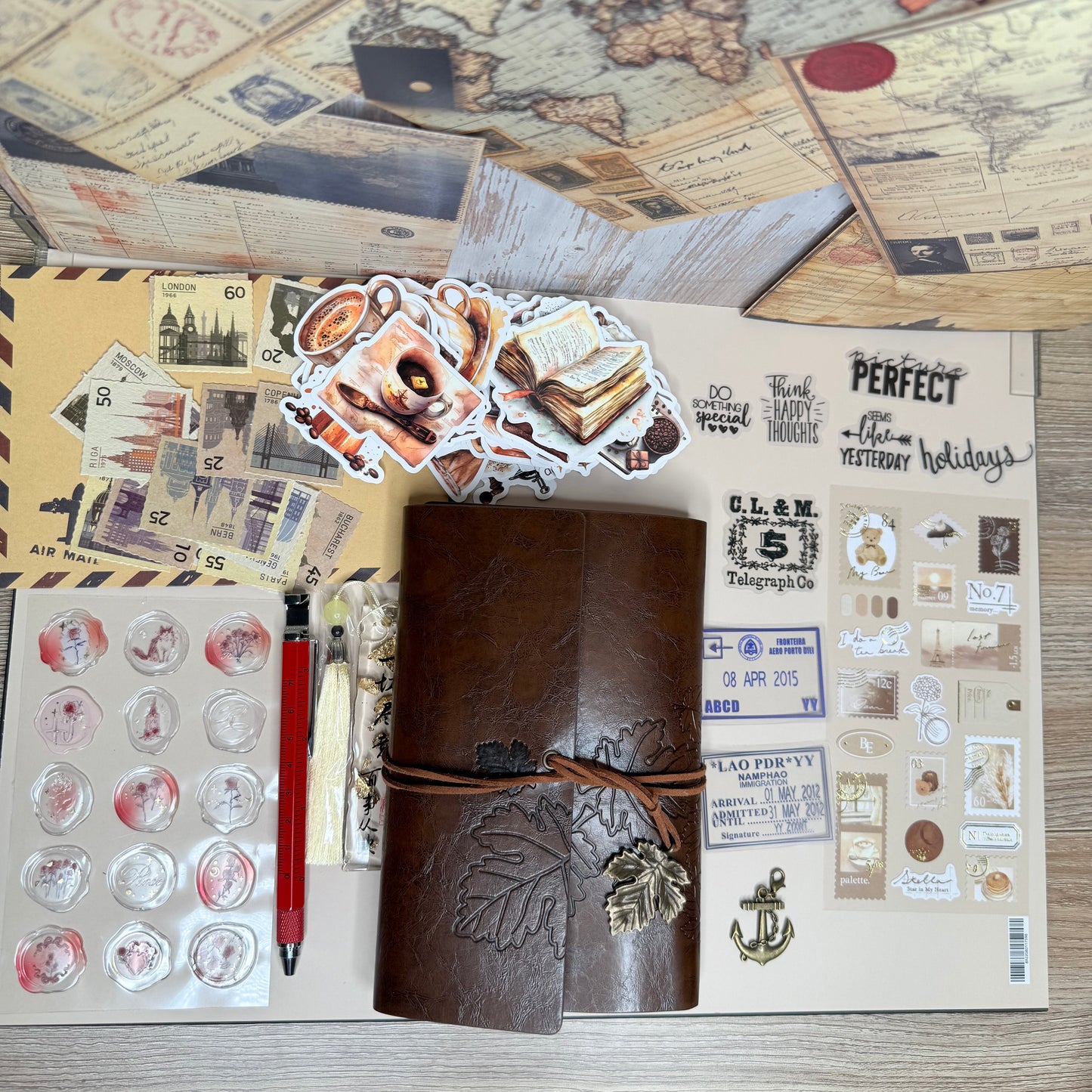 Collection of stationery items including a map, stickers, and a pen on a wooden surface.