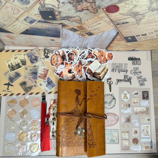 Collection of vintage-style items including a leather-bound book, coins, and decorative paper on a wooden surface.