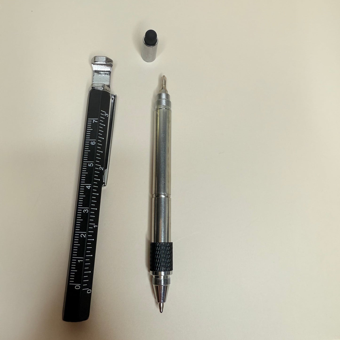 Pen, small round object, and ruler on a light surface