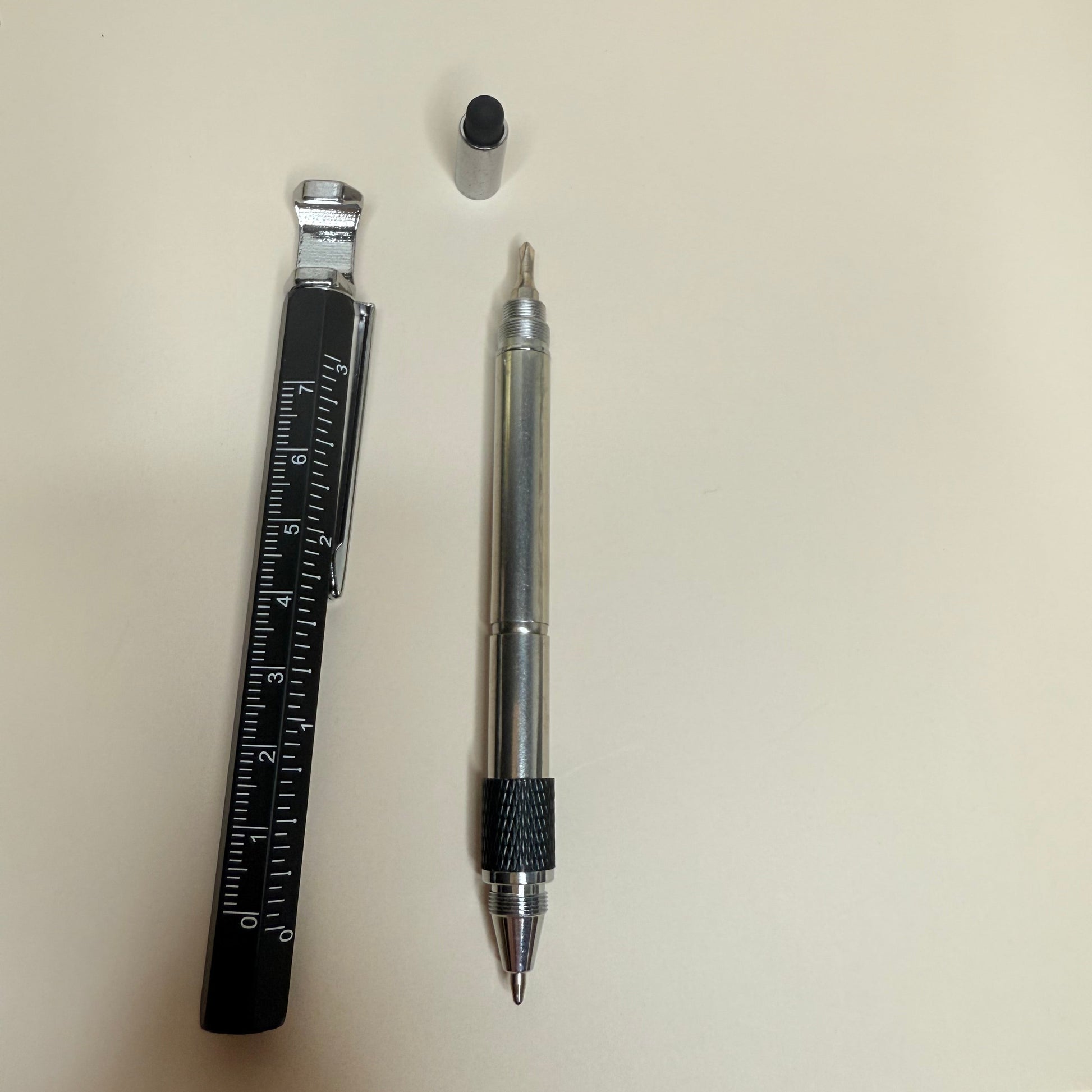 Pen, small round object, and ruler on a light surface