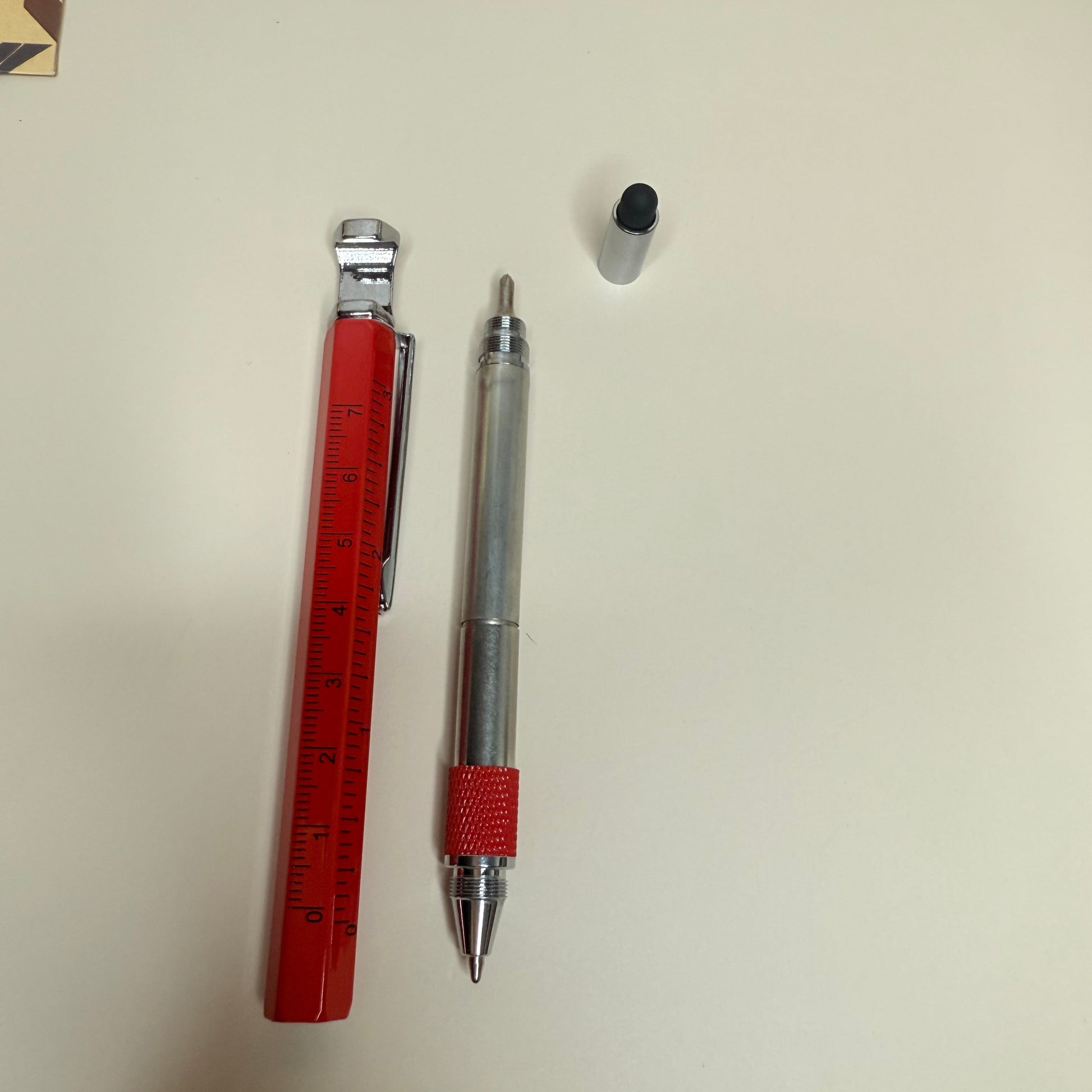 Pen and ruler on a light surface with decorative items around