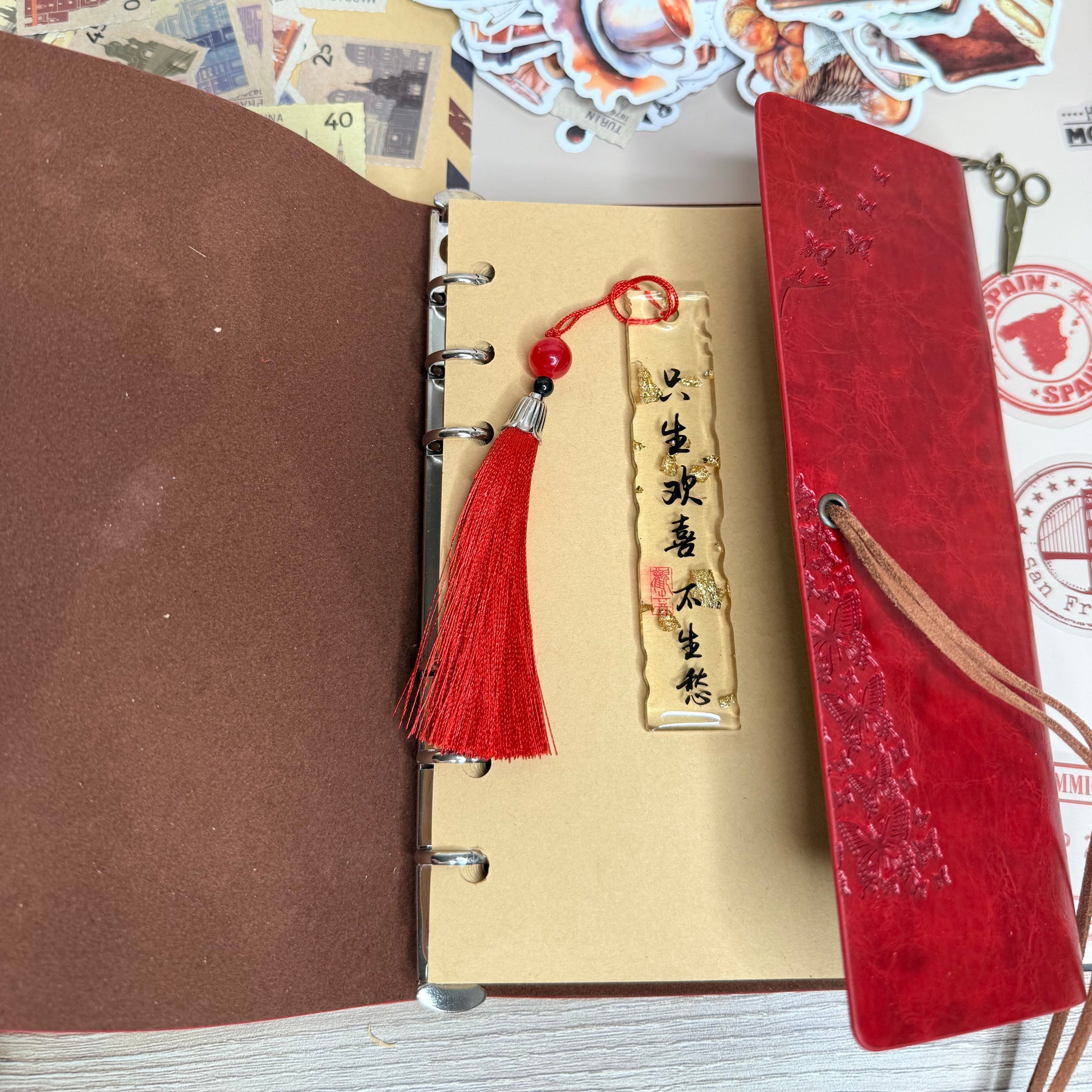 Brown leather notebook with red bookmark and tassel on a wooden surface