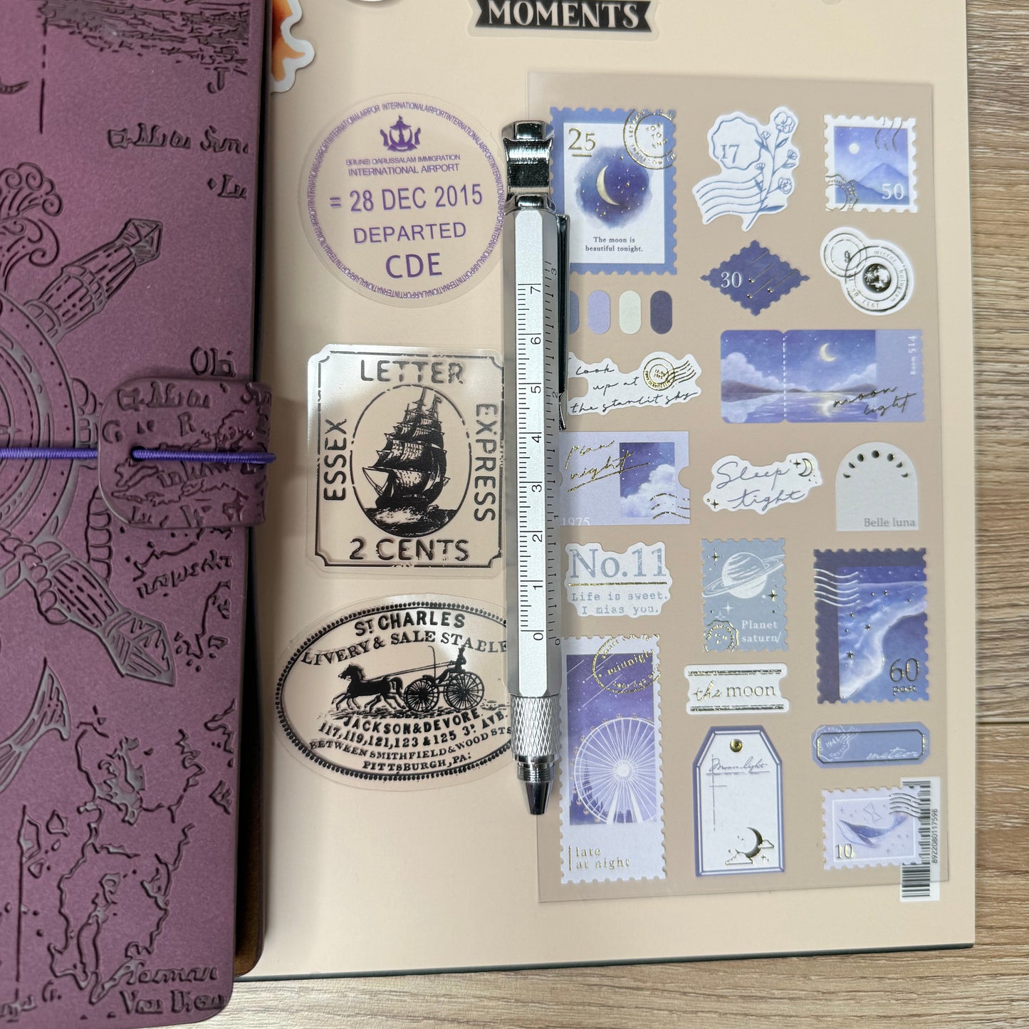 Decorative notebook with stickers and a pen on a wooden surface