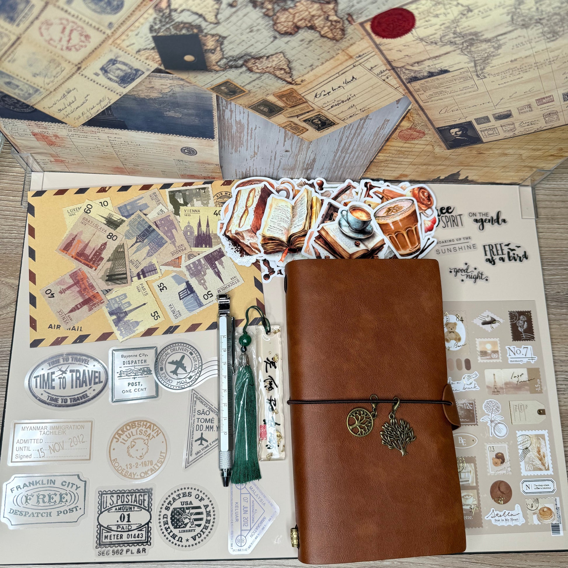 Collection of vintage-style items including a brown leather wallet, stamps, and a world map on a wooden surface.