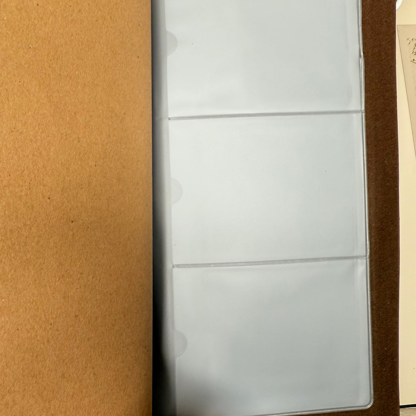 Empty photo album on a wooden surface with a hand holding it open.