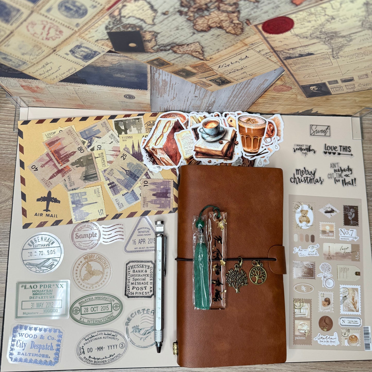 Brown leather travel journal with stamps and a pen on a wooden surface