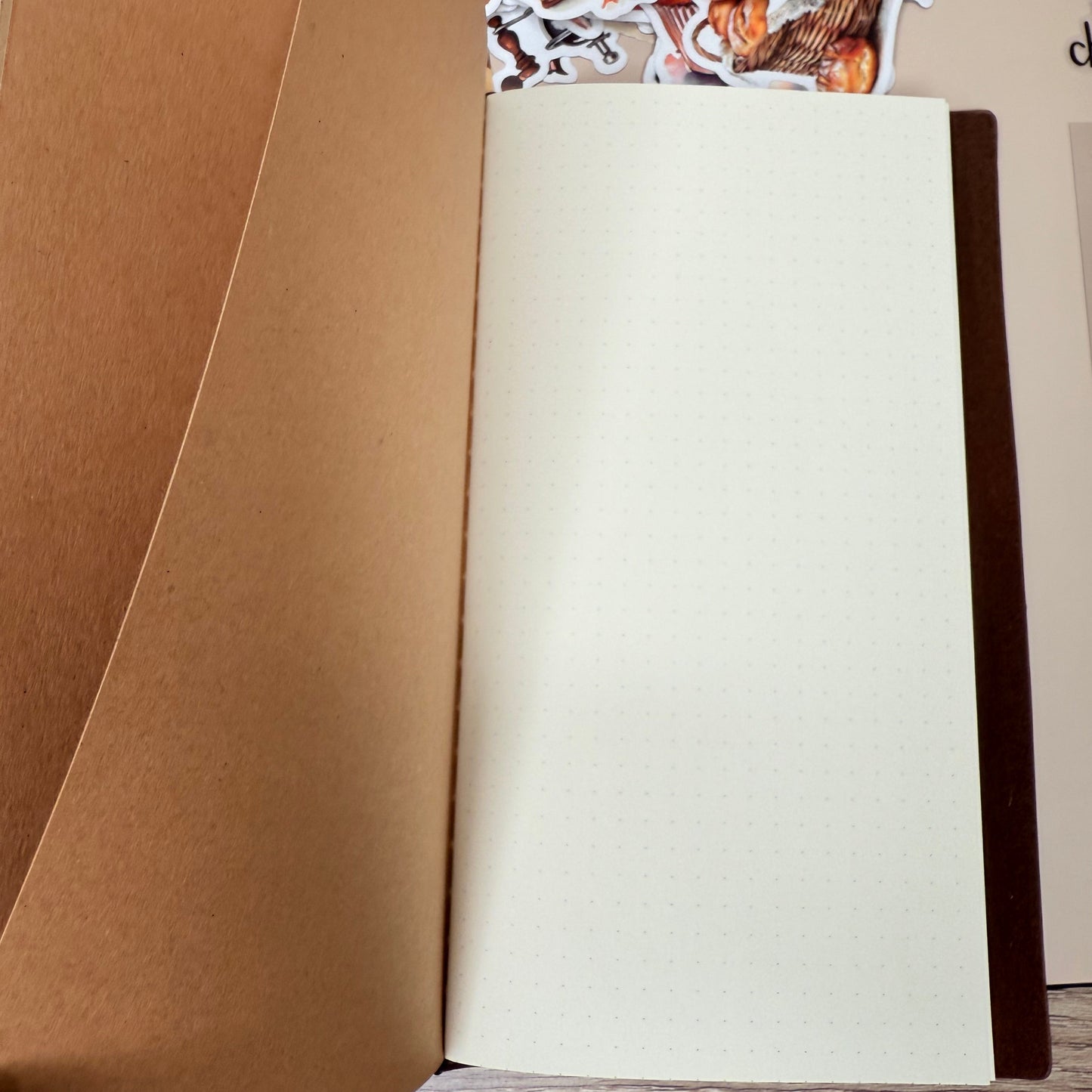 Open notebook with cream-colored pages on a wooden surface