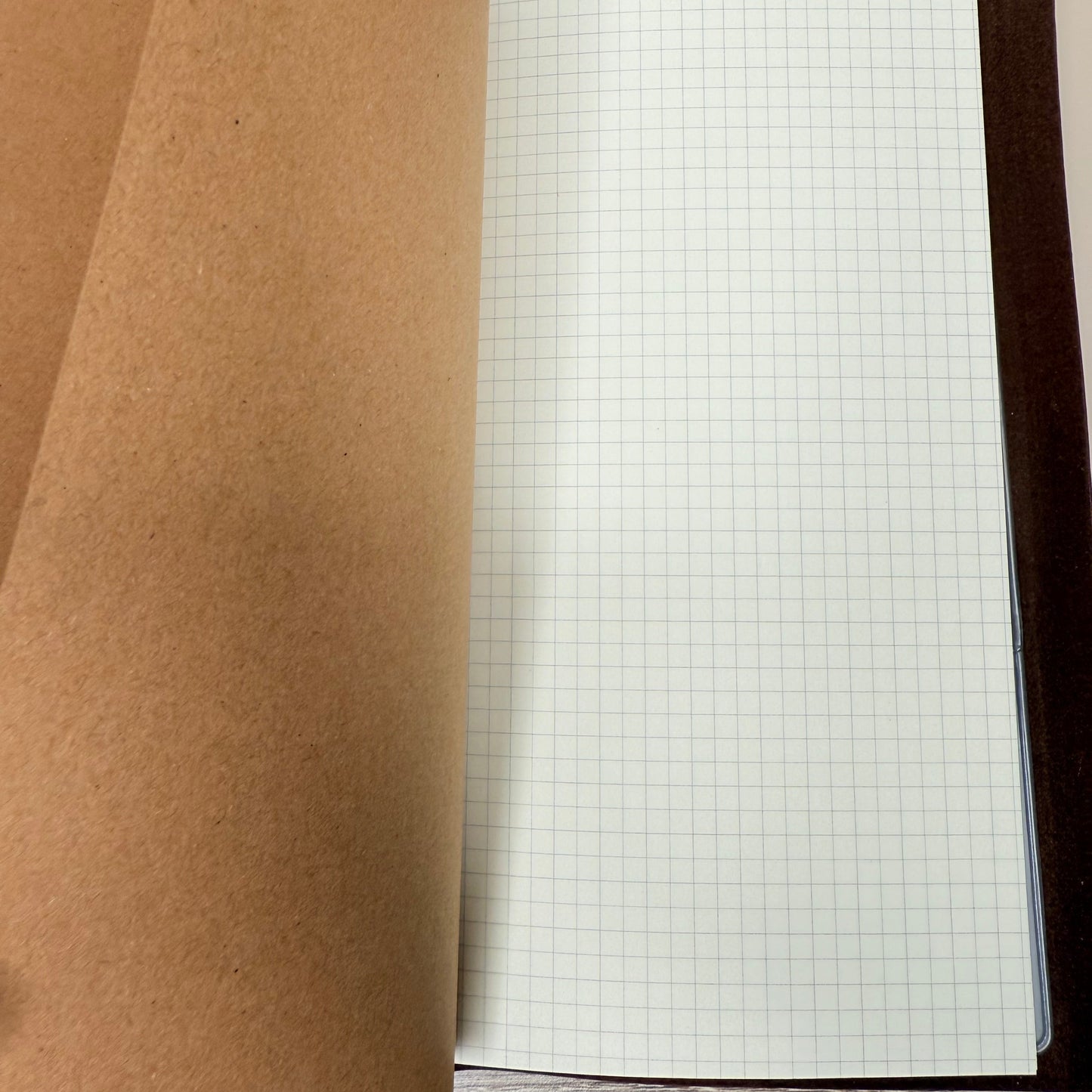 Roll of brown paper with a grid sheet in the background