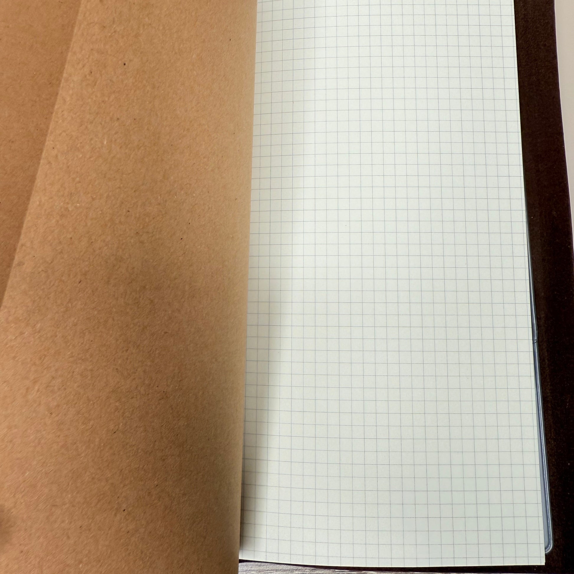 Roll of brown paper with a grid sheet in the background