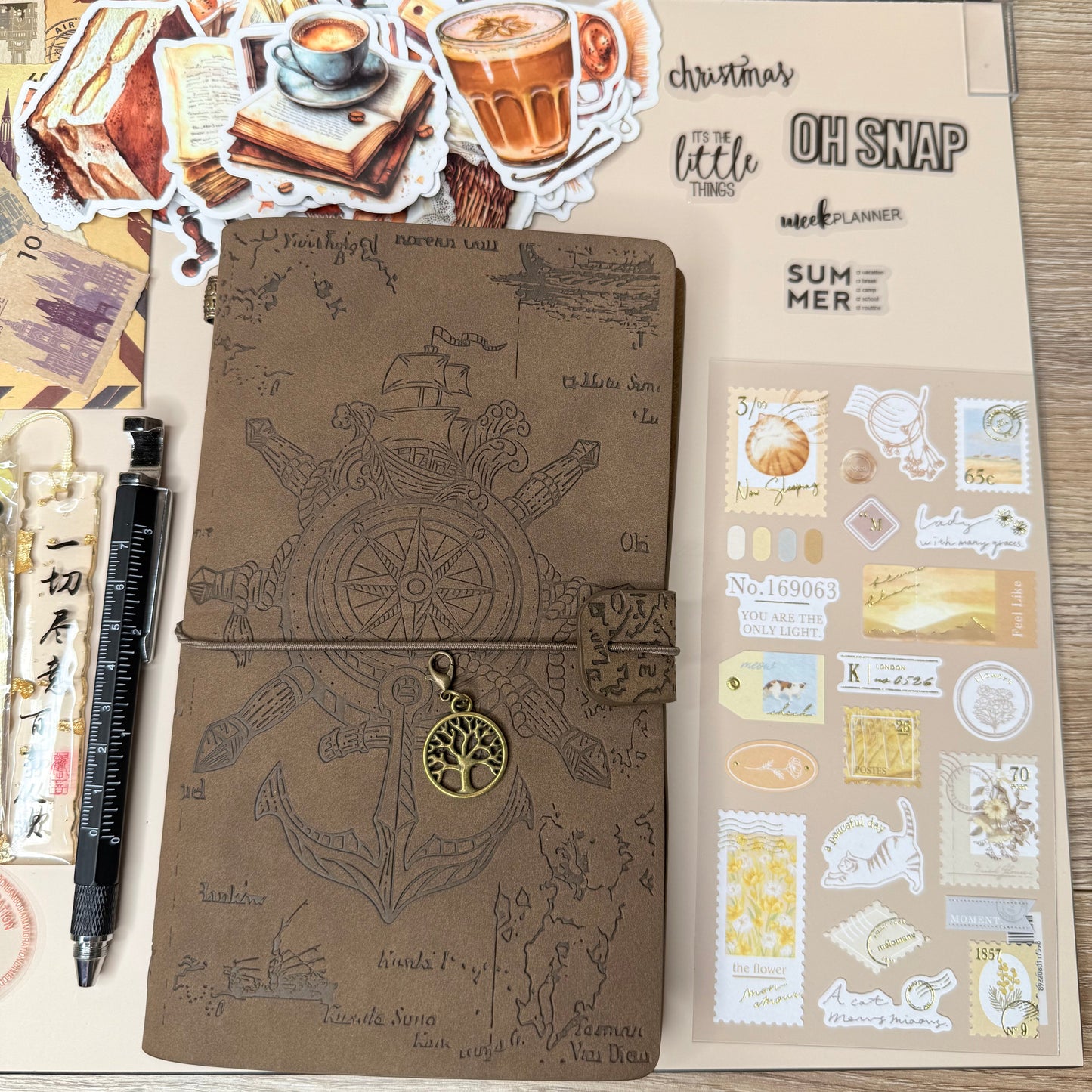 Open notebook with decorative stickers and pen on a wooden surface