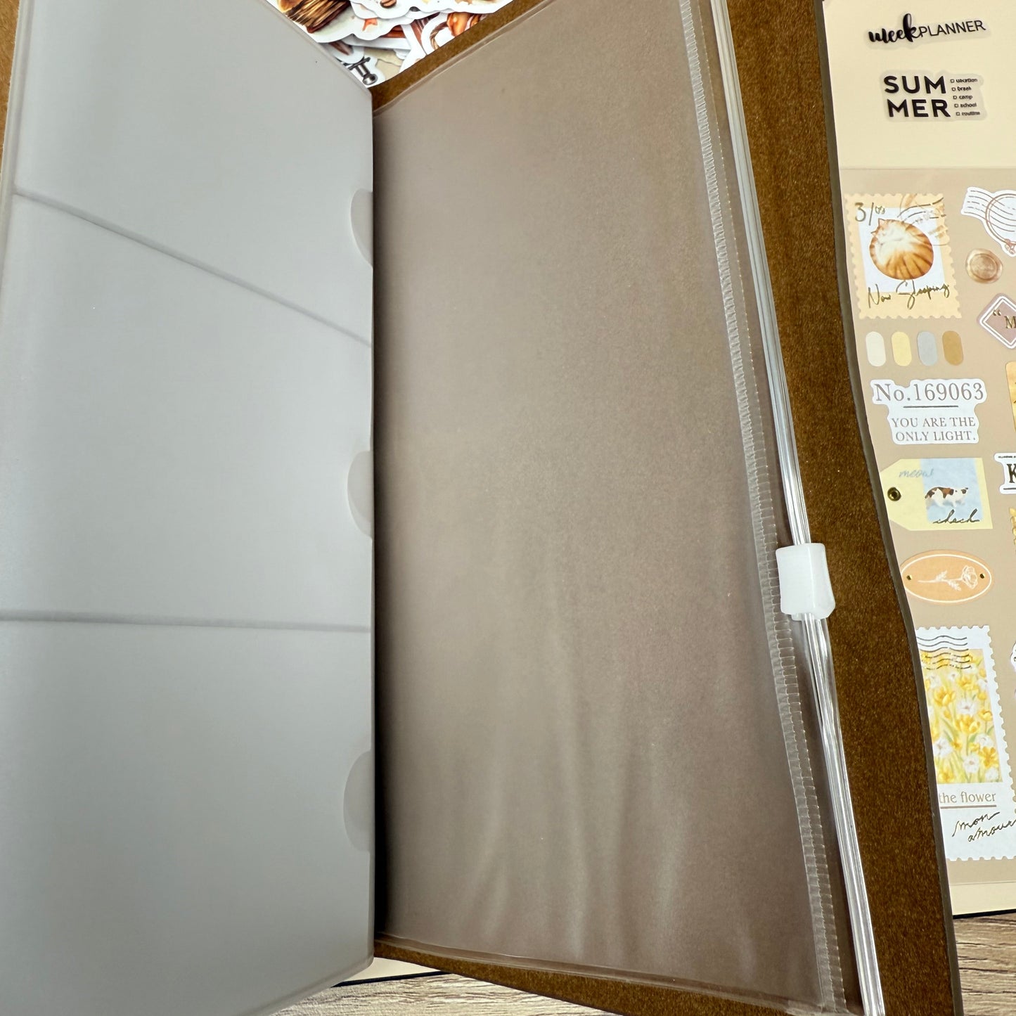 Open beige folder with a wooden frame on a textured wall background