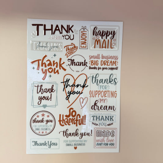Sheet of decorative stamps with various 'thank you' phrases on a beige background.