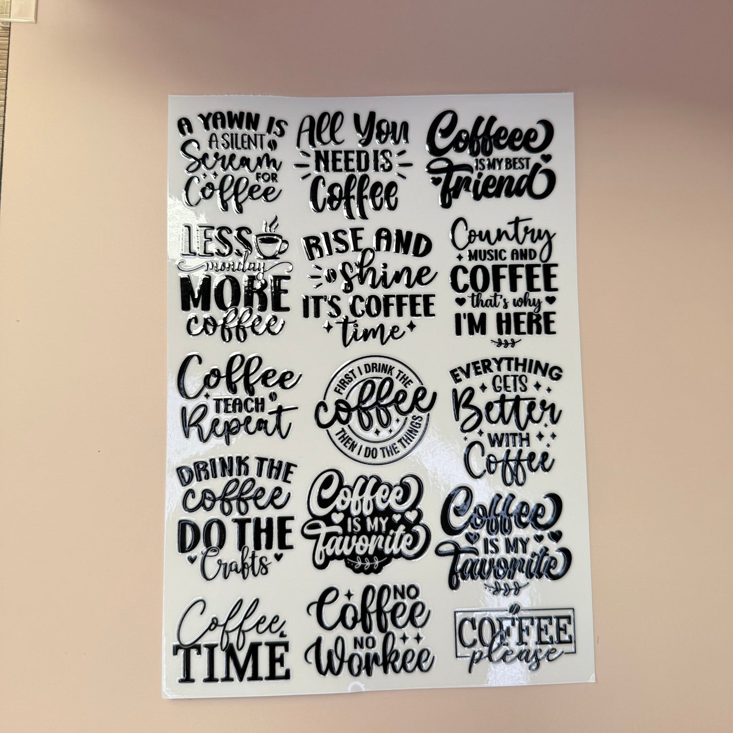 Sheet of coffee-themed stickers with various sayings on a beige background