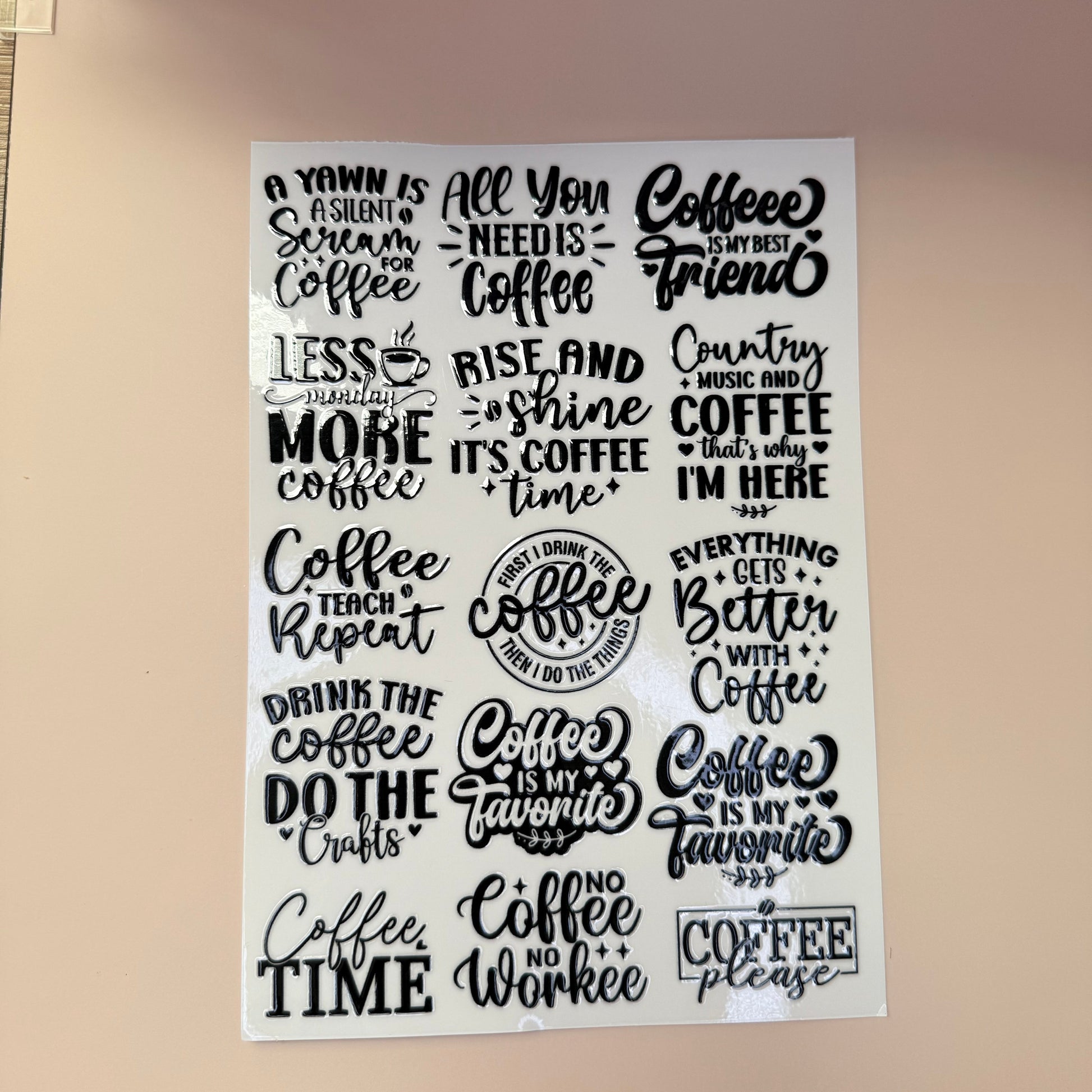 Sheet of coffee-themed stickers with various sayings on a beige background