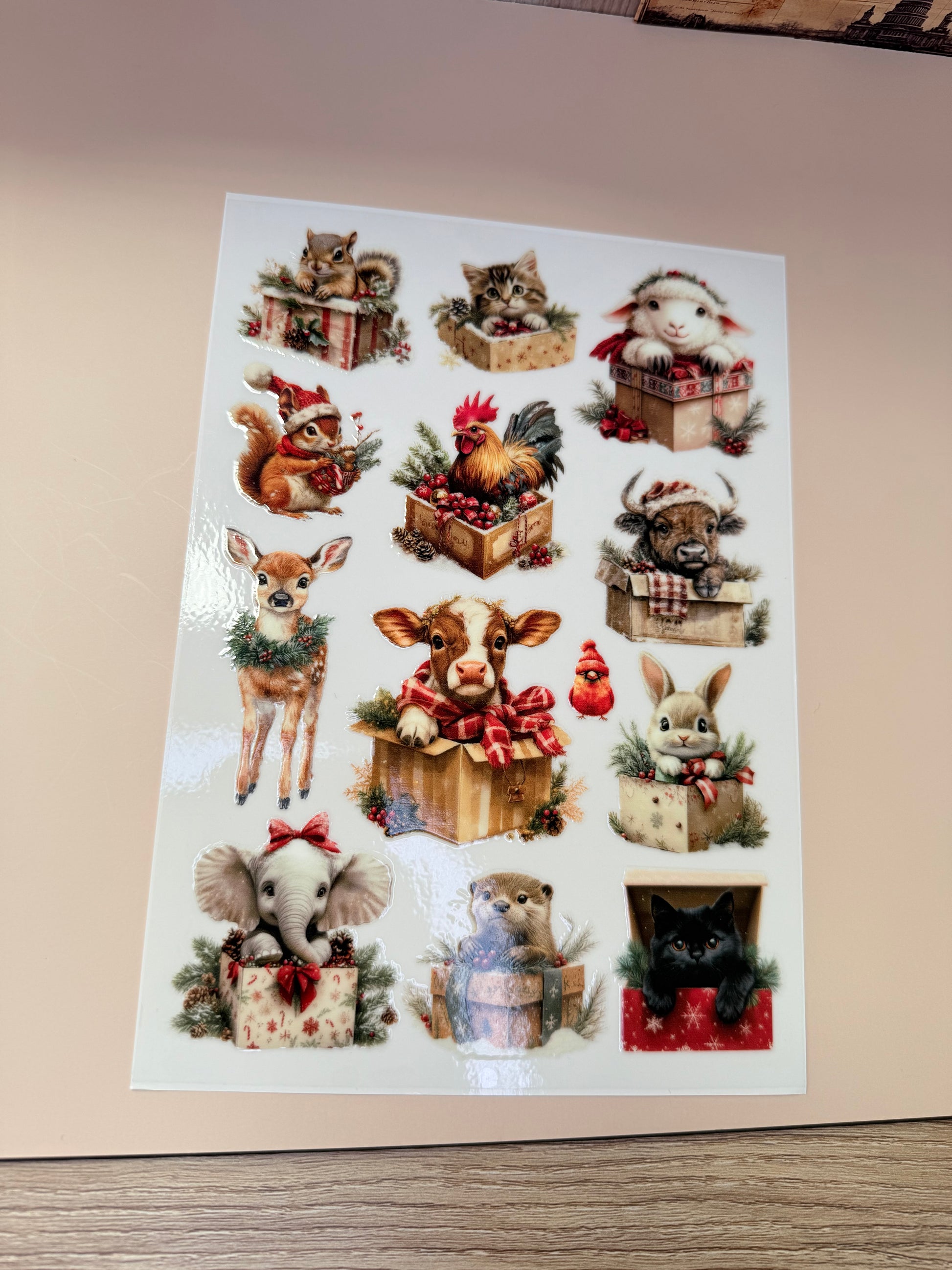 Sheet of decorative stickers with various animal designs on a beige surface.