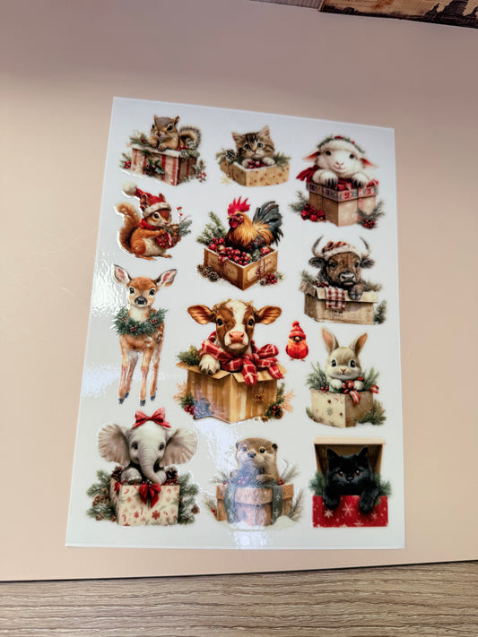 Sheet of decorative stickers with various animal designs on a beige surface.