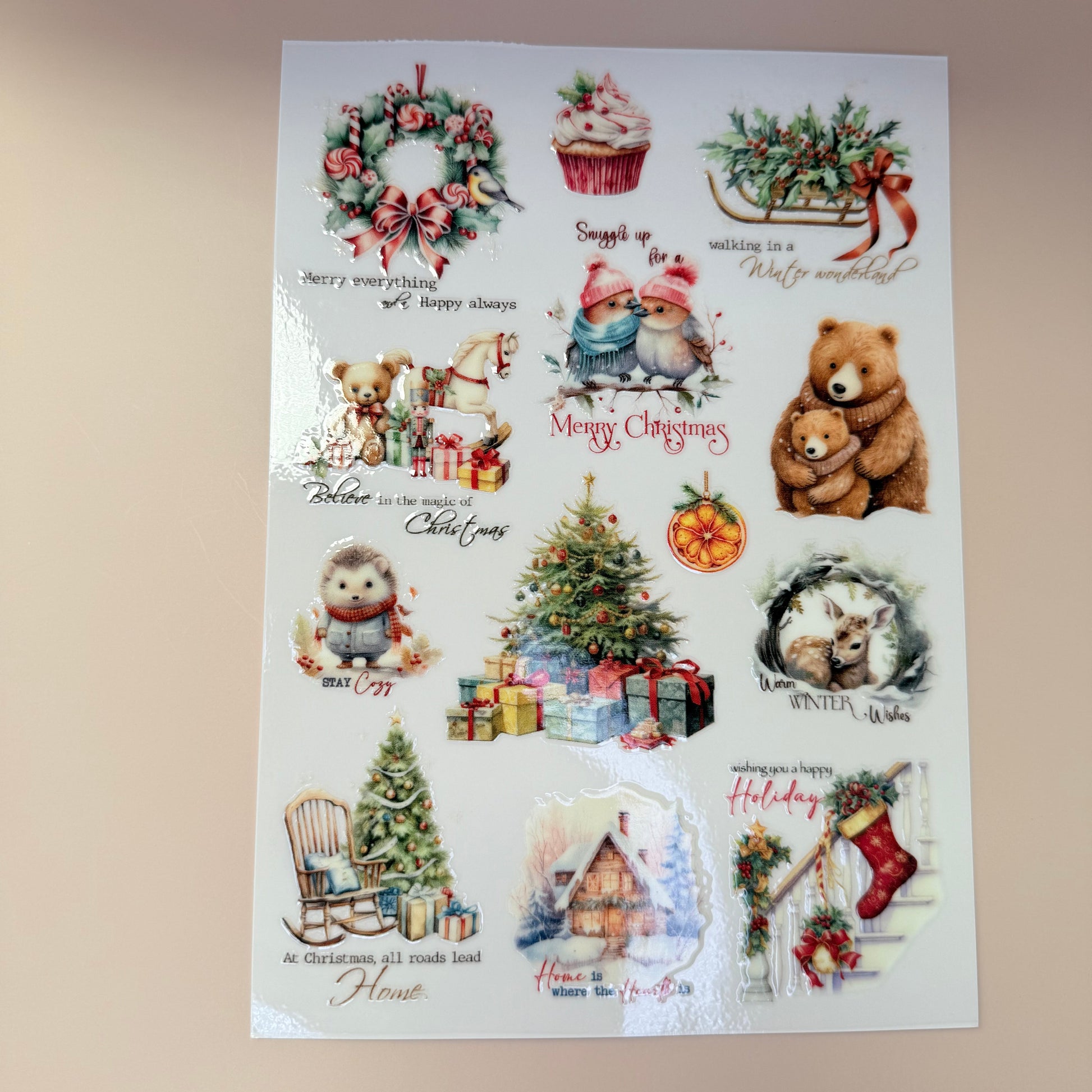 Sheet of Christmas-themed stickers with bears, trees, and wreaths on a beige background.