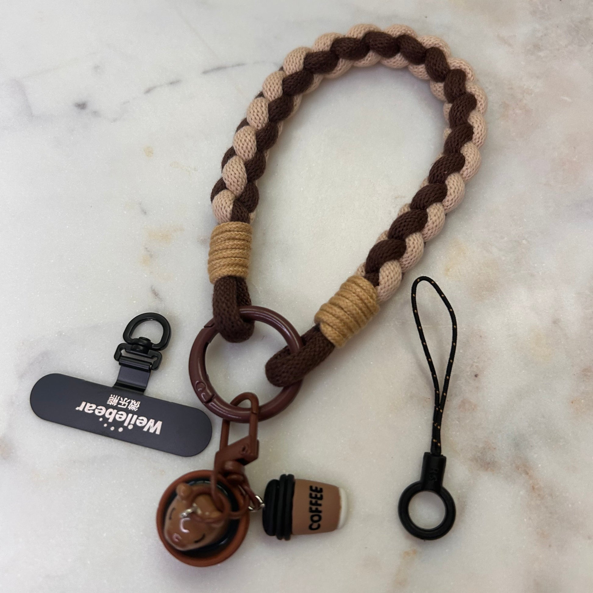 Keychain with braided design and attached tags on a marble surface