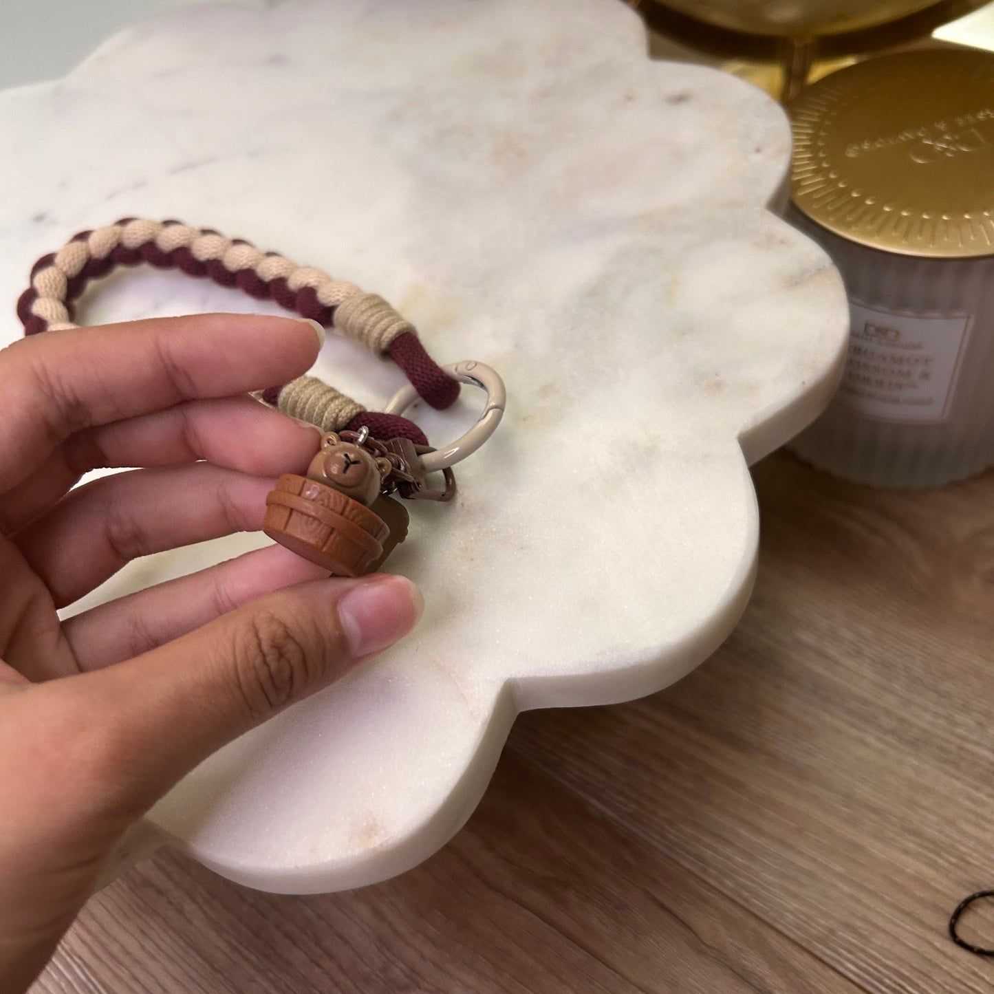 Hand holding a keychain with a marble-like object in the background