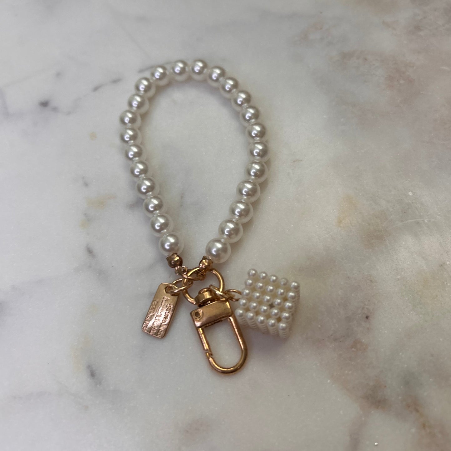 Pearl bracelet with gold clasp on a marble surface