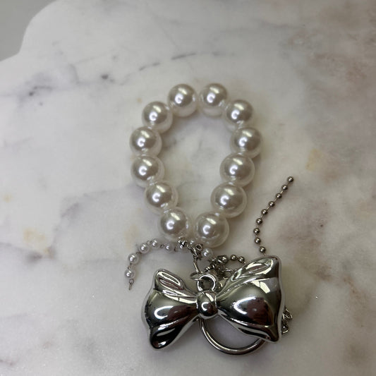 Pearl necklace with a silver pendant on a marble surface