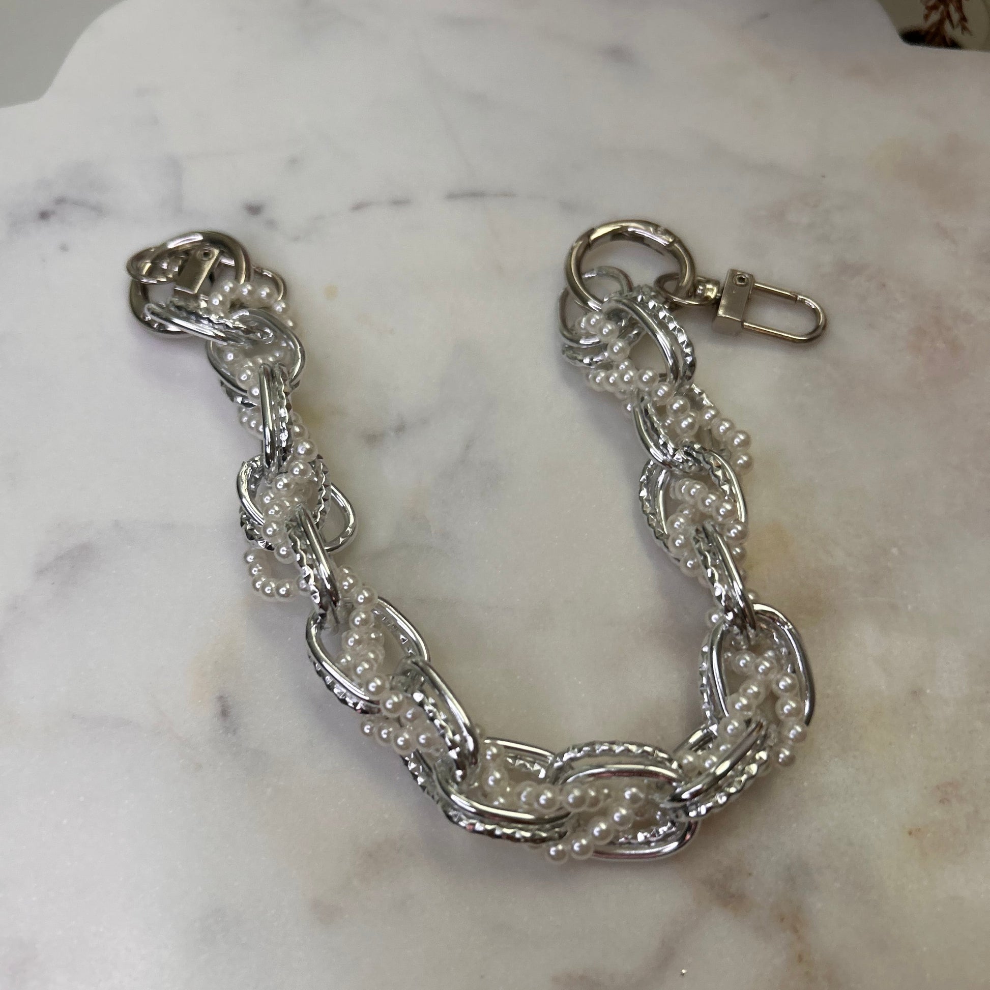 Silver chain bracelet on a marble surface